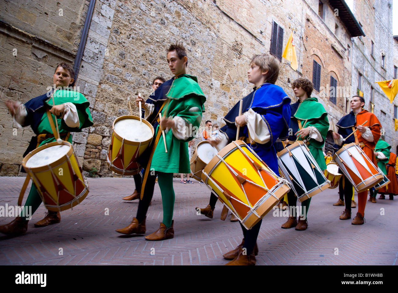 Italia Toscana San Gimignano ragazzi e giovani uomini in costume medievale di tamburi in sfilata per le strade durante il corteo storico Foto Stock