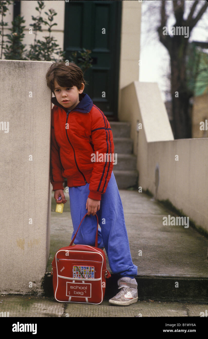 Bambino seduto sulla porta di attesa per i genitori per tornare a casa Foto Stock