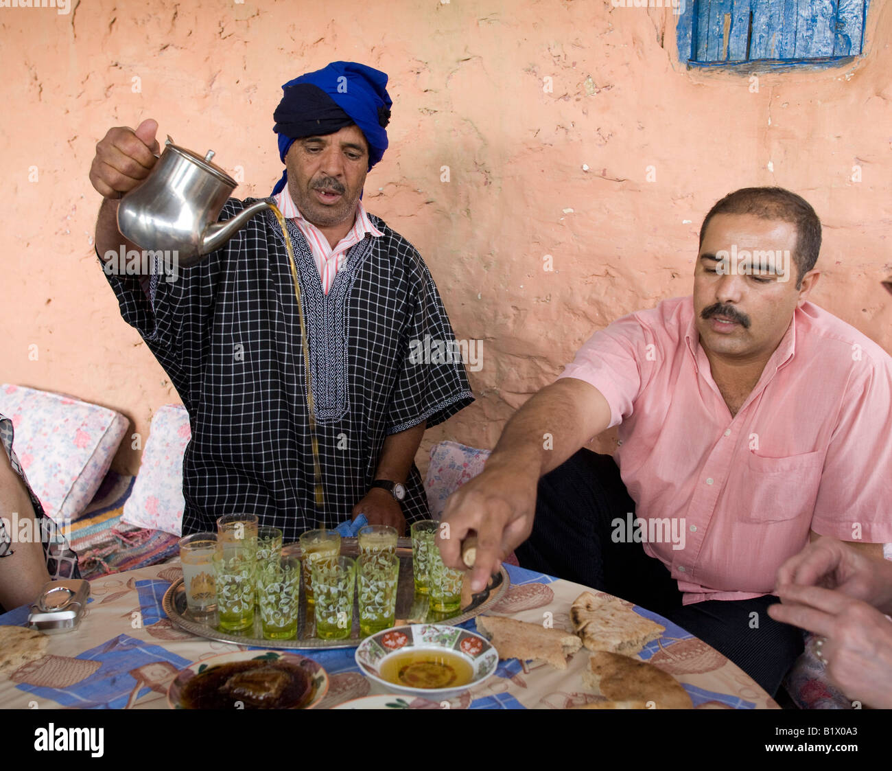 Morocan Touareg pastore con turbante blu rivolto verso serve te.89287 Marocco Foto Stock