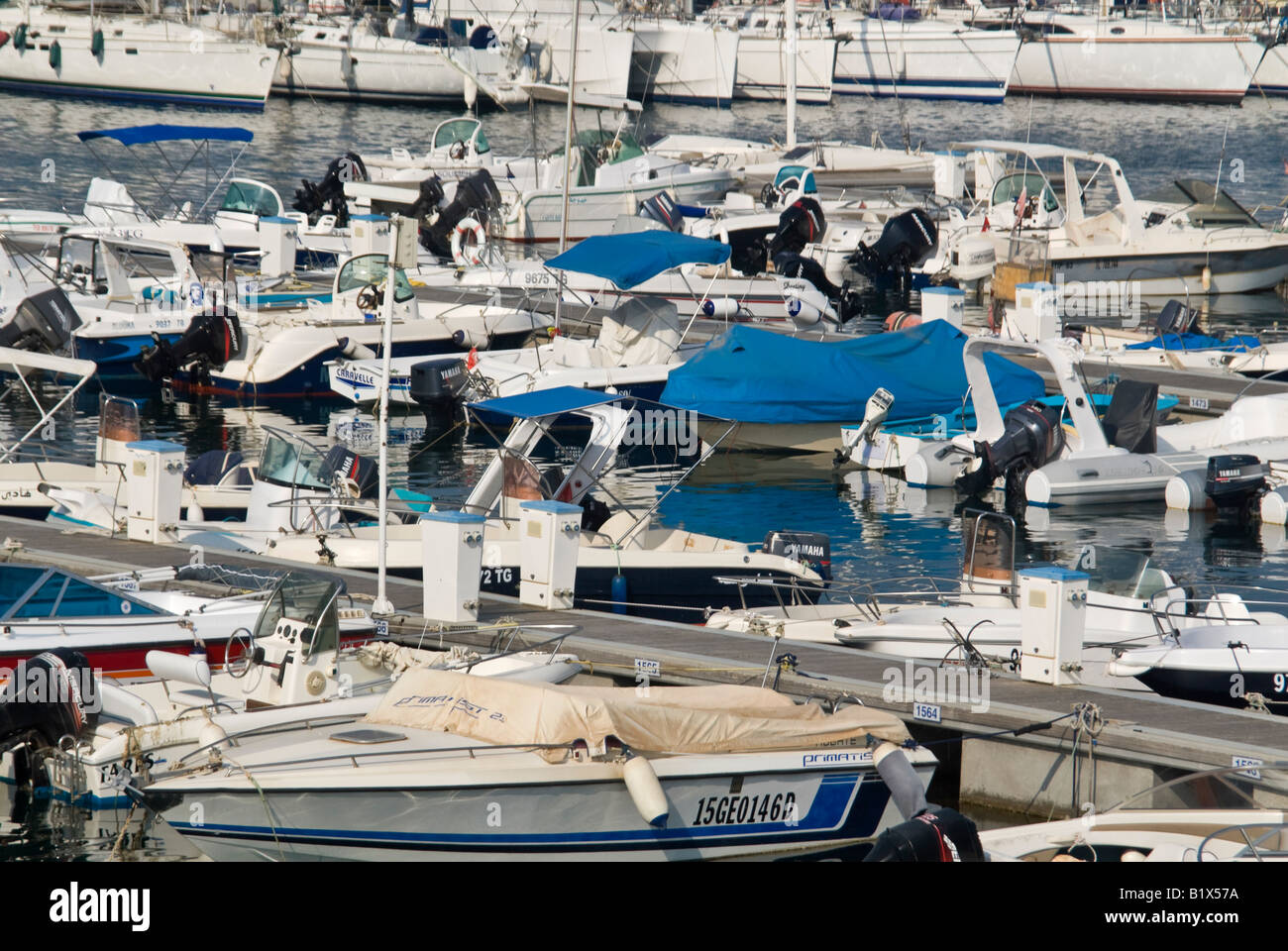 Orizzontale vista elevata attraverso un affollato porticciolo con costosi Yacht e Motoscafi Ormeggiato accanto al molo in una giornata di sole Foto Stock