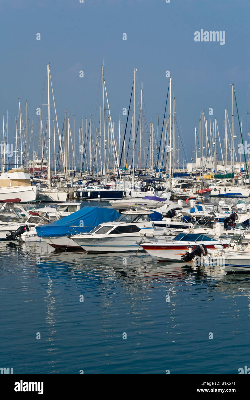 Verticale vista elevata attraverso un affollato porticciolo con un sacco di costose yacht ormeggiato in una fila al fianco del molo in una giornata di sole Foto Stock