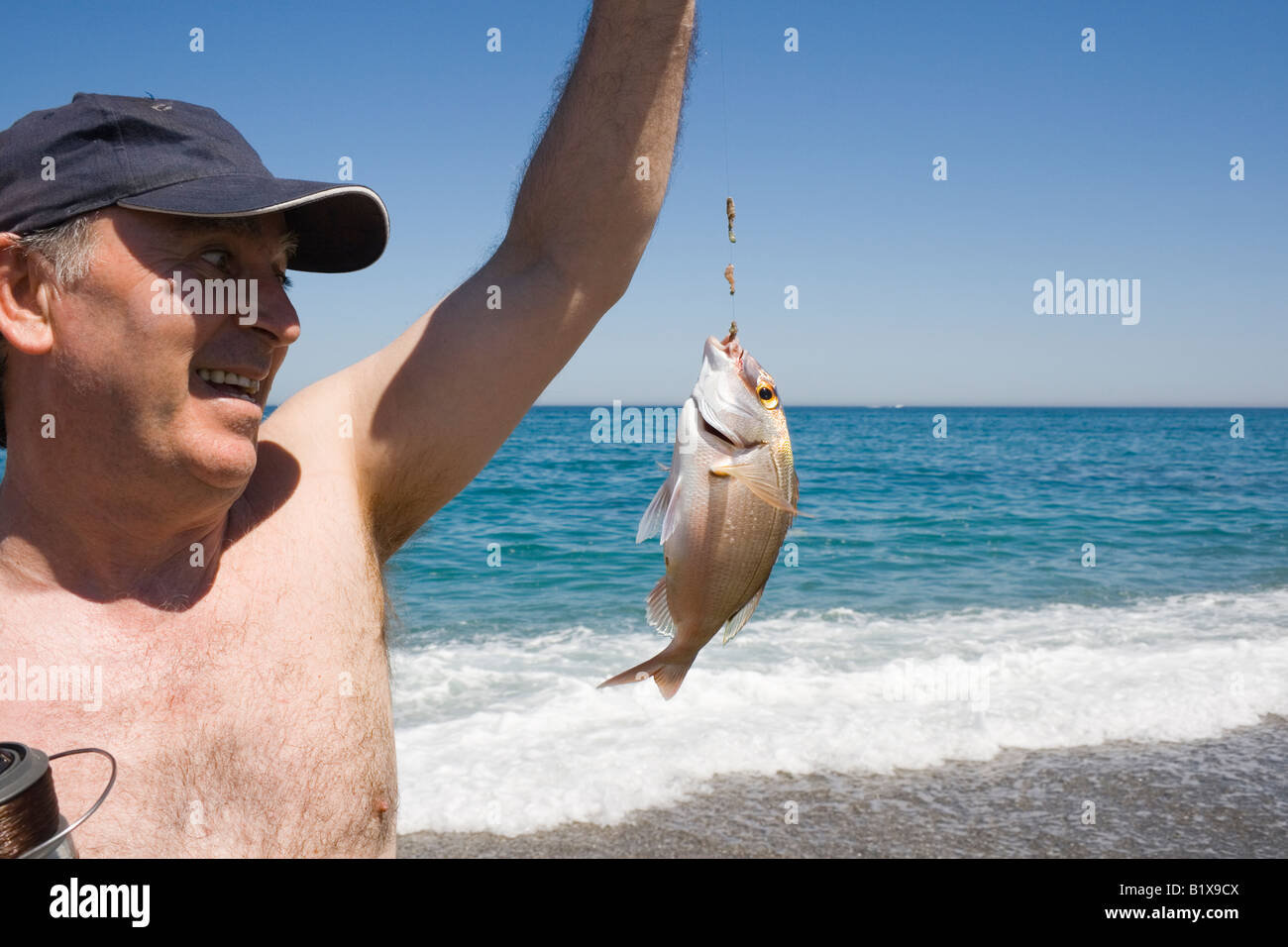 Pescatore con pesce fresco pescato Foto Stock