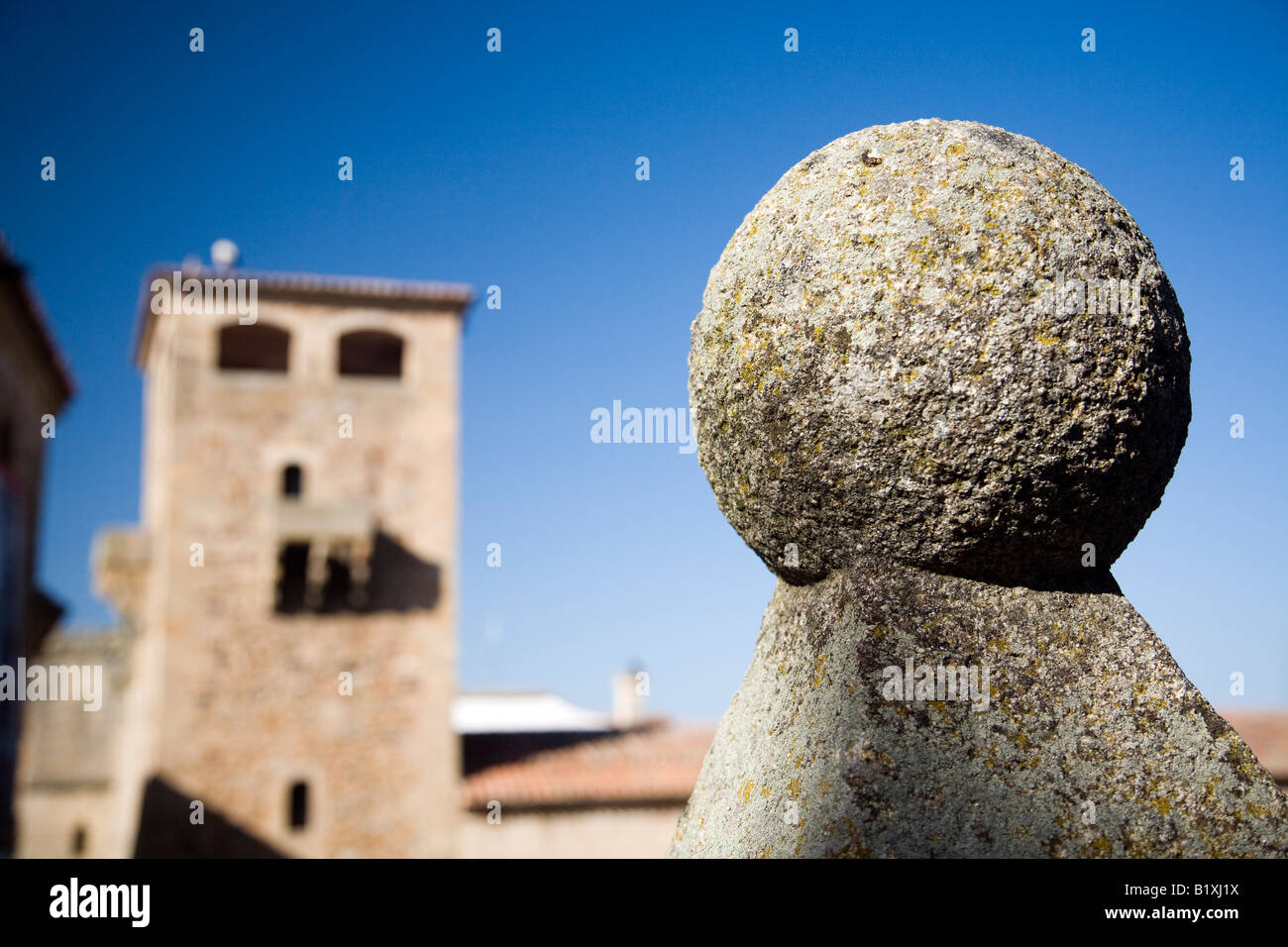 Graniti ornamentali sfera con la torre di Golfines de Abajo palace sullo sfondo, San Jorge square, Caceres, Spagna Foto Stock