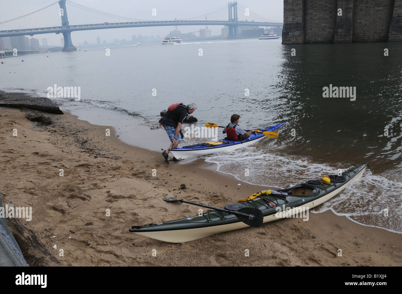 Una piccola spiaggia sotto il ponte di Brooklyn sul lato di Manhattan della East River è un benvenuto in luogo di riposo per kayakers. Foto Stock
