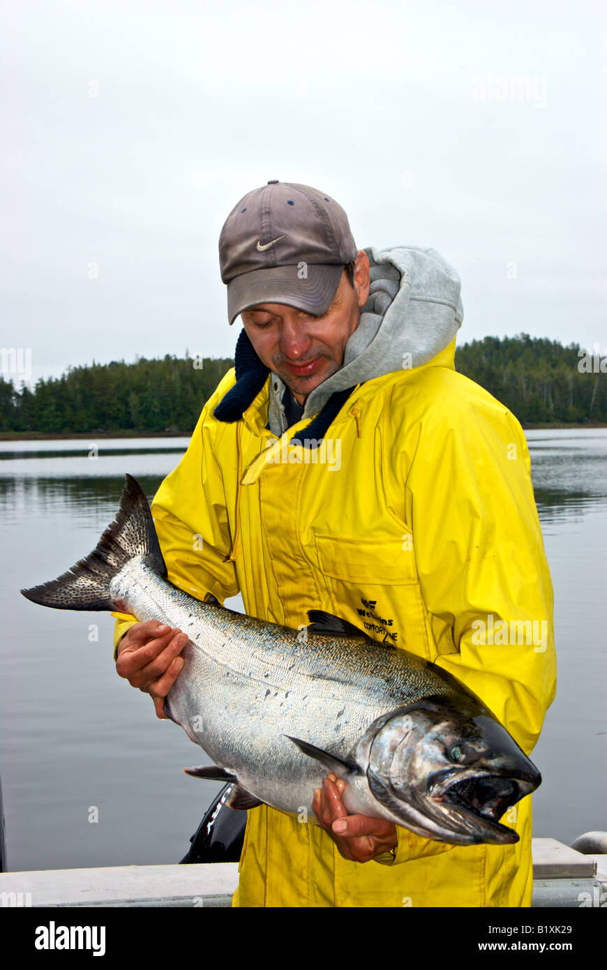 Pescatore maschio tenendo un grande trofeo troll catturati Northern British Columbia Salmone Chinook pesce Foto Stock