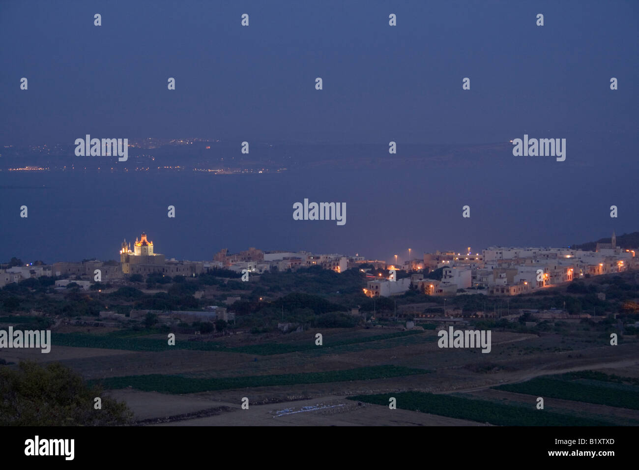 Il villaggio di Ghajnsielem, Gozo, come si vede da Nadur altezze. Il nord di Malta è visibile attraverso il canale. Foto Stock