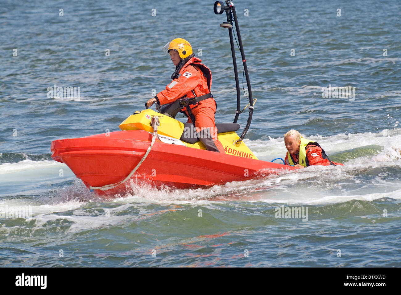 Il salvataggio in mare boatman salva distressed persona e prende lui/lei al di fuori dell'acqua con facilità e velocità Foto Stock