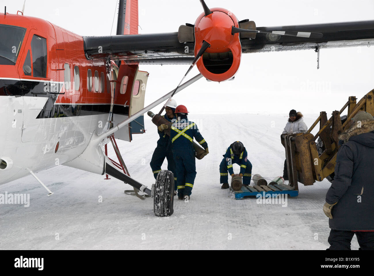 I lavoratori nel settore petrolifero e del gas a carico Twin Otter aeromobili con parti. Pista di ghiaccio in The Beaufort Sea, Artico Canadese. Foto Stock