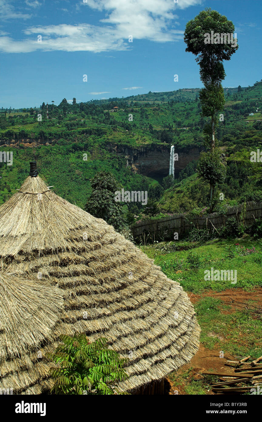 Vista della capanna con tetto di paglia verso Sipi Falls e vegetazione tropicale Mbale Uganda Africa Foto Stock