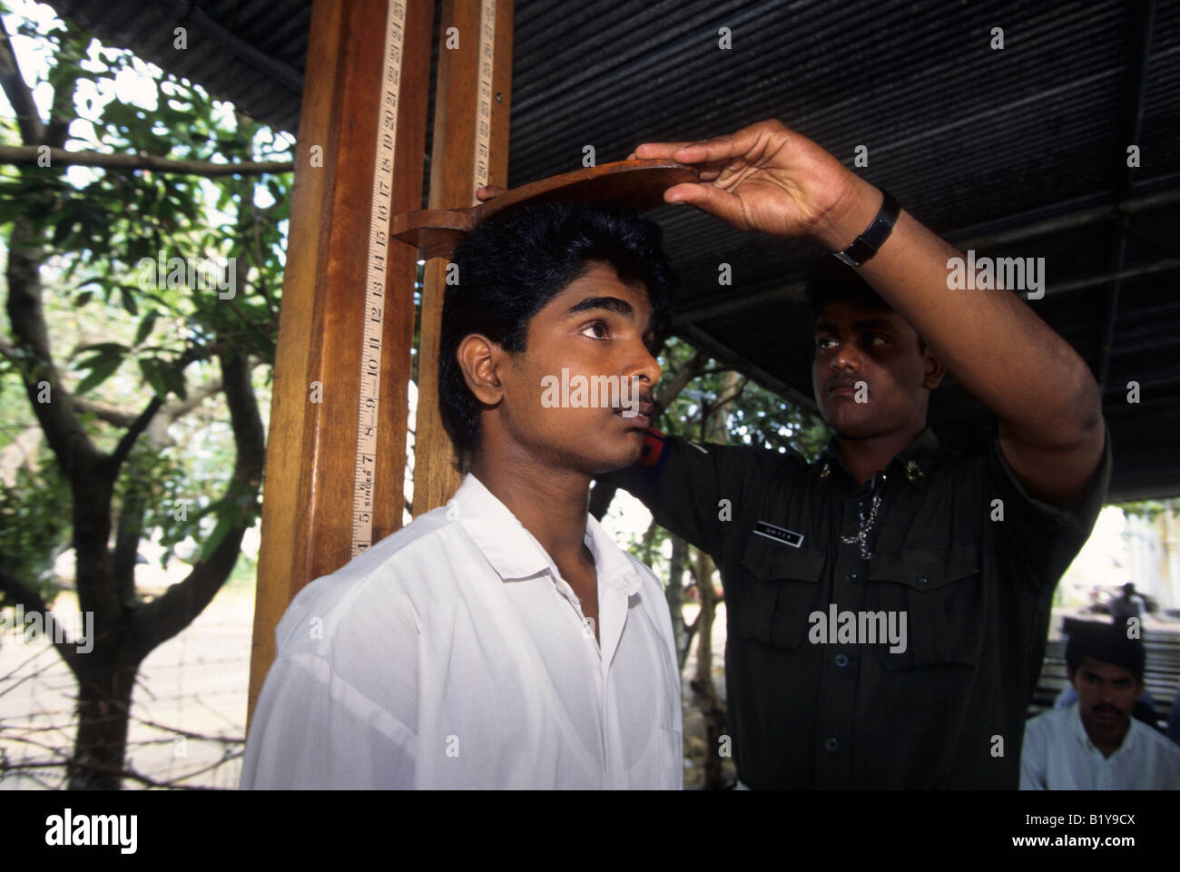 Una recluta ha la sua altezza misurata da un esercito srilankese officer in Colombo Sri Lanka Foto Stock
