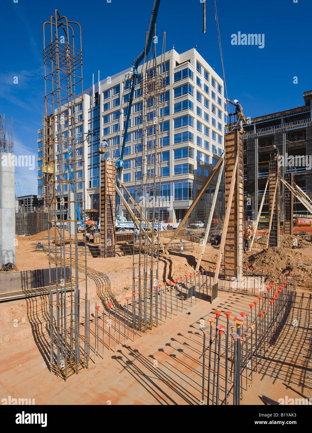 Lavoratori edili in piedi in cima a forme concrete di attesa per il pour Foto Stock