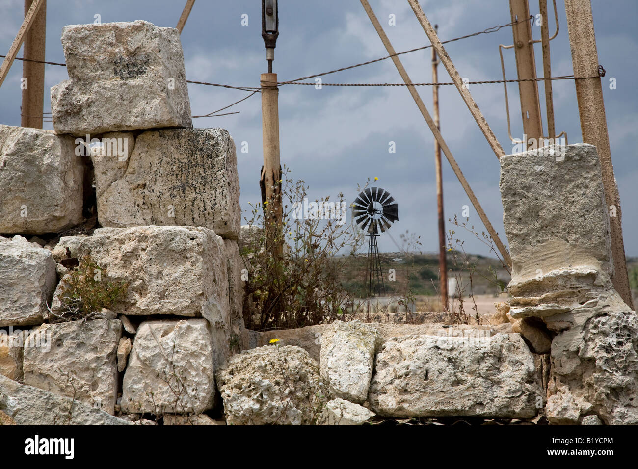 Fattoria in pietra muro di confine e in disuso il pompaggio di acqua ferro vecchio maso agricolo di mulini a vento, Mellieħa Malta Foto Stock