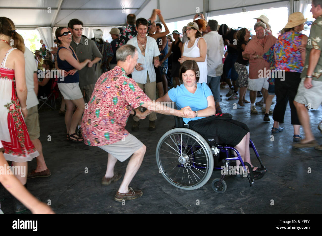 Una donna su una sedia a rotelle balli presso la sala economia tenda a New Orleans Jazz e Heritage Festival, New Orleans, LA, STATI UNITI D'AMERICA Foto Stock