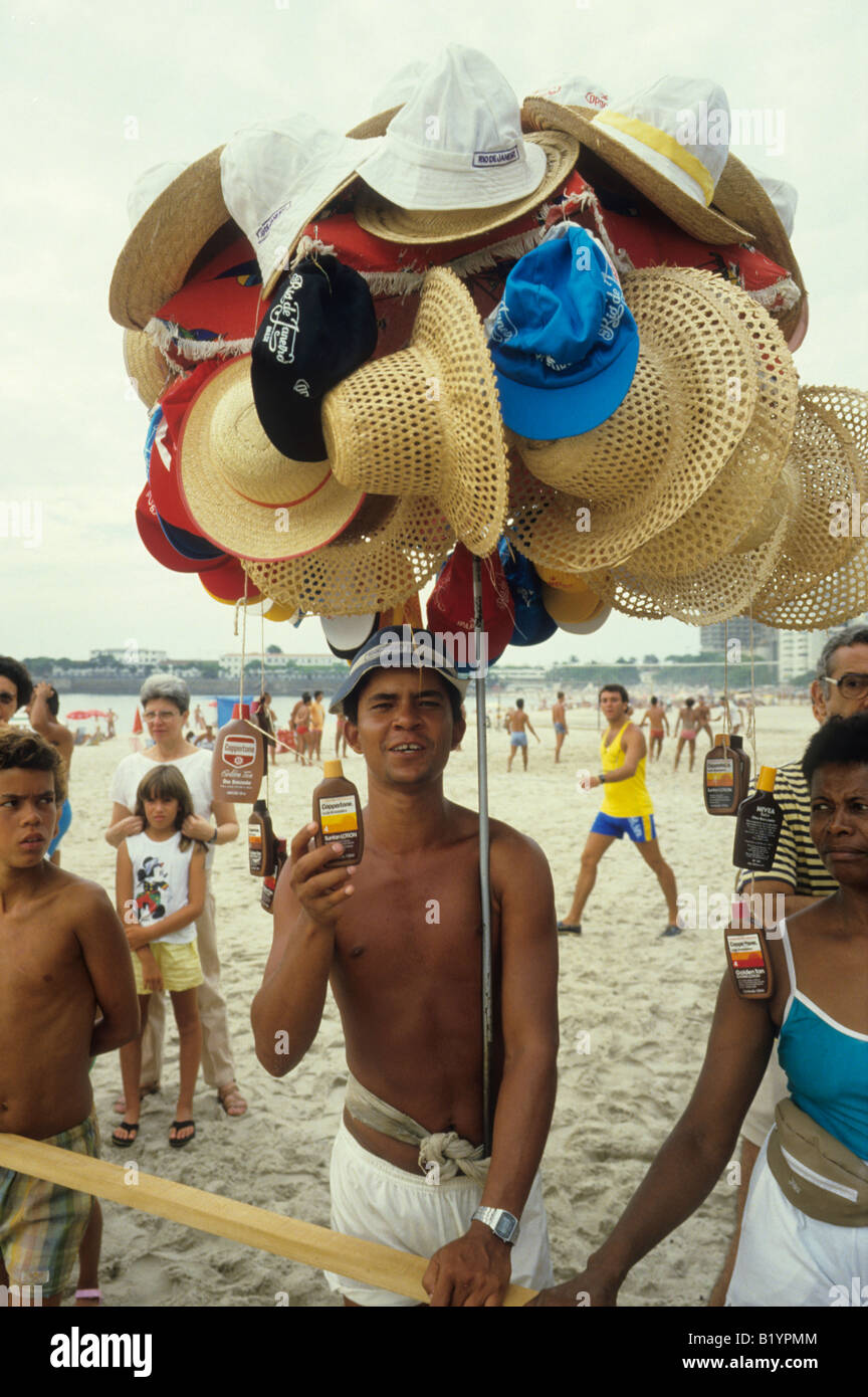Un venditore mostra la sua mercanzia di cappelli e lo schermo parasole lozione a Rio de Janeiro in Brasile Foto Stock