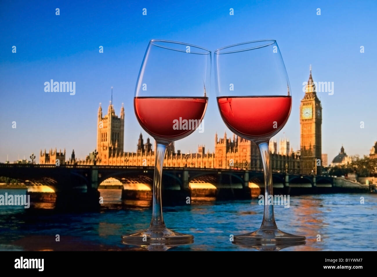 Rosato due bicchieri di vino che si inclina verso l'altra con le case del Parlamento e Westminster Bridge dietro a Londra England Regno Unito Foto Stock