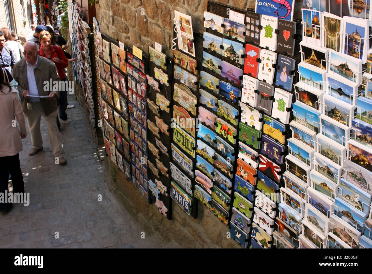 Cartoline postali e cartoline in vendita nelle strette strade di Mont Saint Michel, in Normandia, Francia Foto Stock