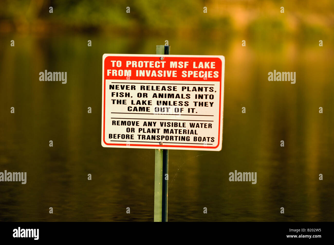 Segno nel lago di avvertimento contro il rilascio di Piante invasive Foto Stock
