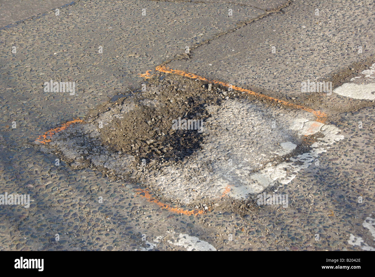 Buche stradali ispezionate e contrassegnate con vernice rossa per indicare la necessità di un lavoro di riparazione del foro del vaso Essex Inghilterra UK Foto Stock