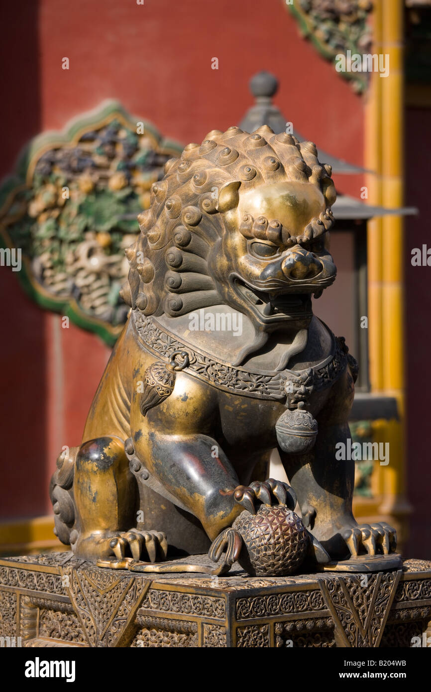 Maschio dorato lion statua con palla sotto la zampa nel palazzo imperiale la Città Proibita di Pechino CINA Foto Stock