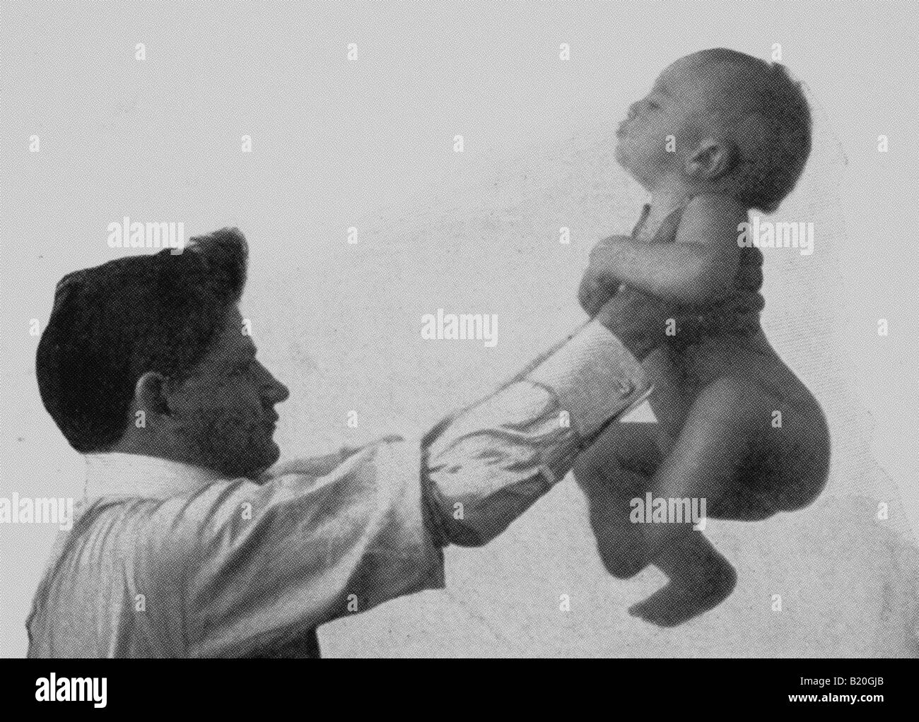 Foto storiche del bambino di sollevamento le mani sotto le armi Foto Stock