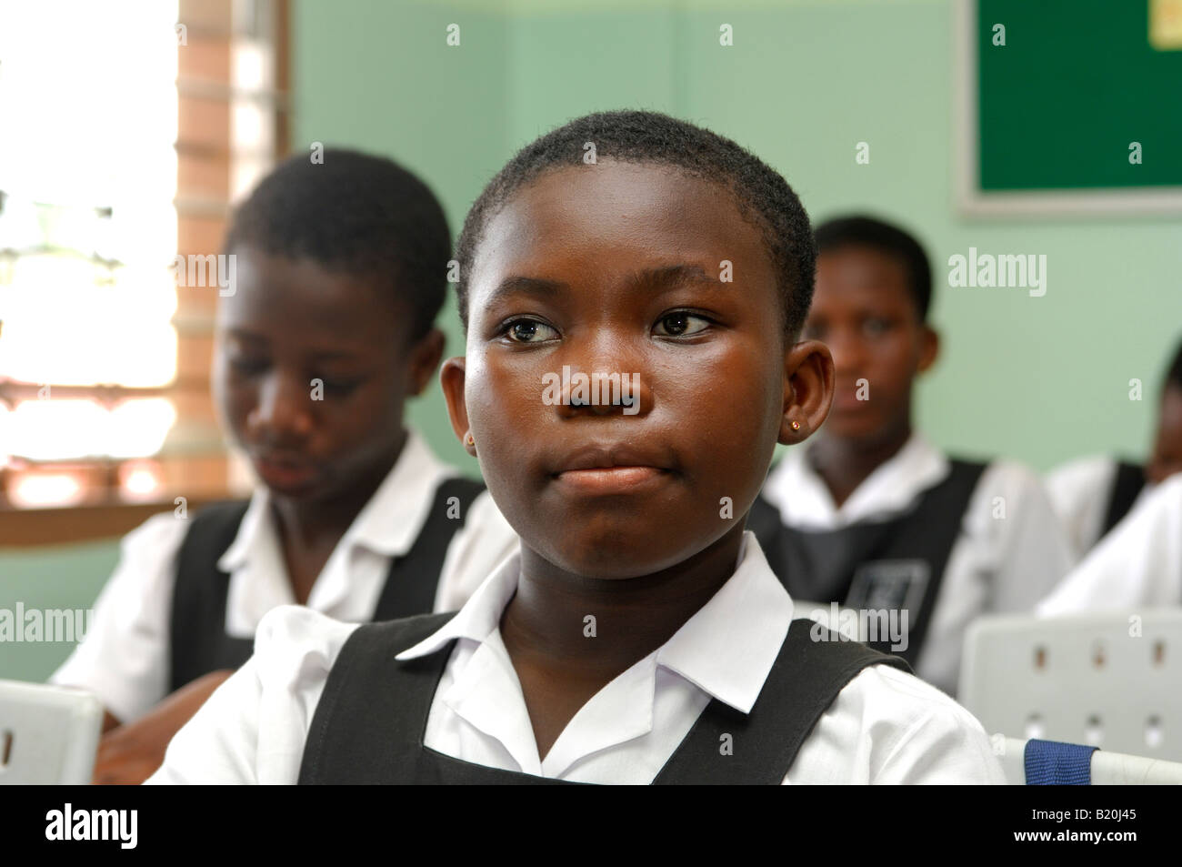 Attento ragazza in una classe del De ragazzi Scuola Internazionale, Accra, Ghana Foto Stock