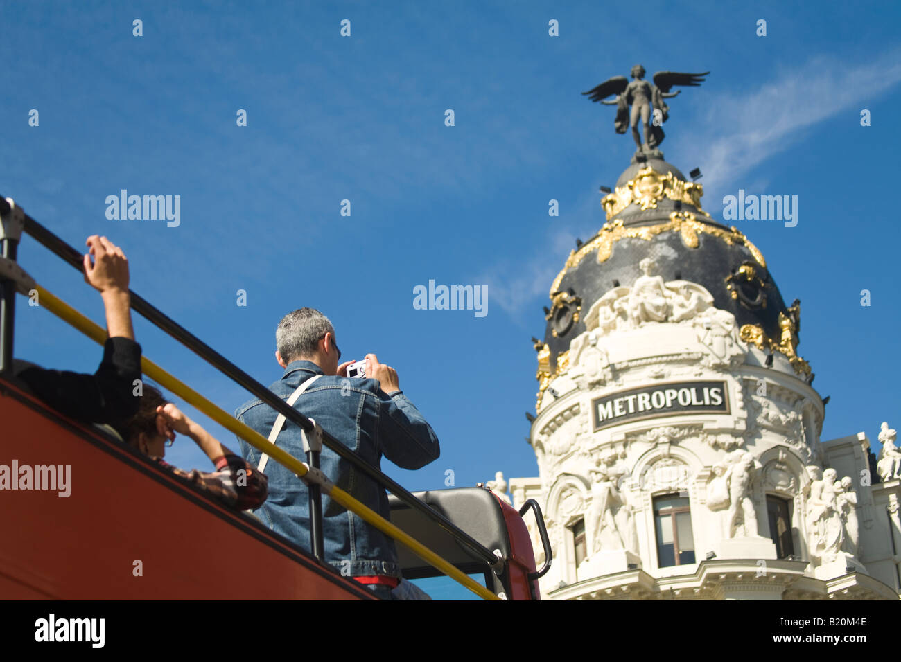 Spagna Madrid Tourist con la fotocamera sul livello superiore del double decker bus tour di scattare foto di Metropolis edificio sulla Gran Via Foto Stock