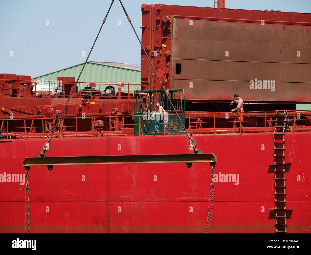 Due uomini al lavoro su una grande nave rossa porto di Anversa Fiandre Belgio Foto Stock