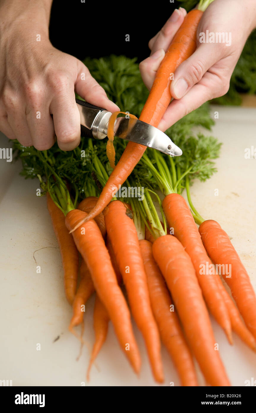 Una giovane donna Pela le carote fresche raccolte da un giardino urbano  Foto stock - Alamy