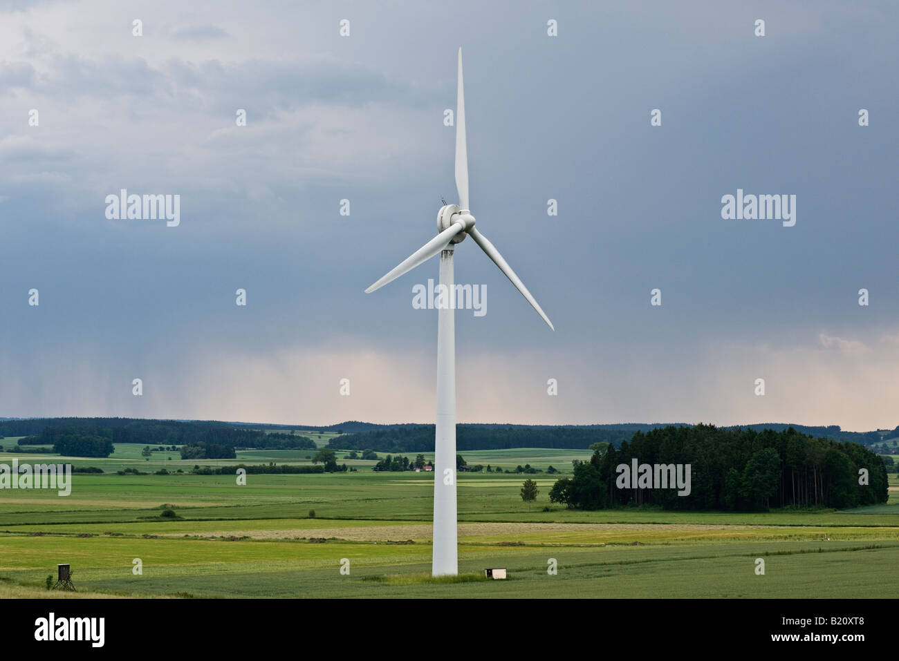 Generazione di potenza della turbina eolica si siede tra i campi di orzo Baviera Germania Foto Stock
