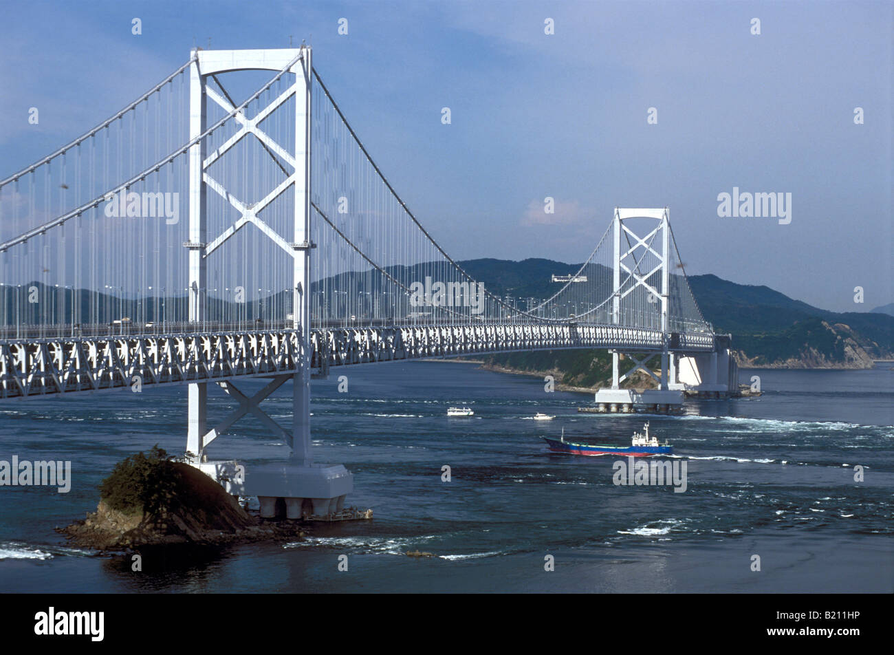 Freighter passando sotto il ponte di naruto passato i mulinelli di Naruto stretto vicino Awajima Giappone Foto Stock