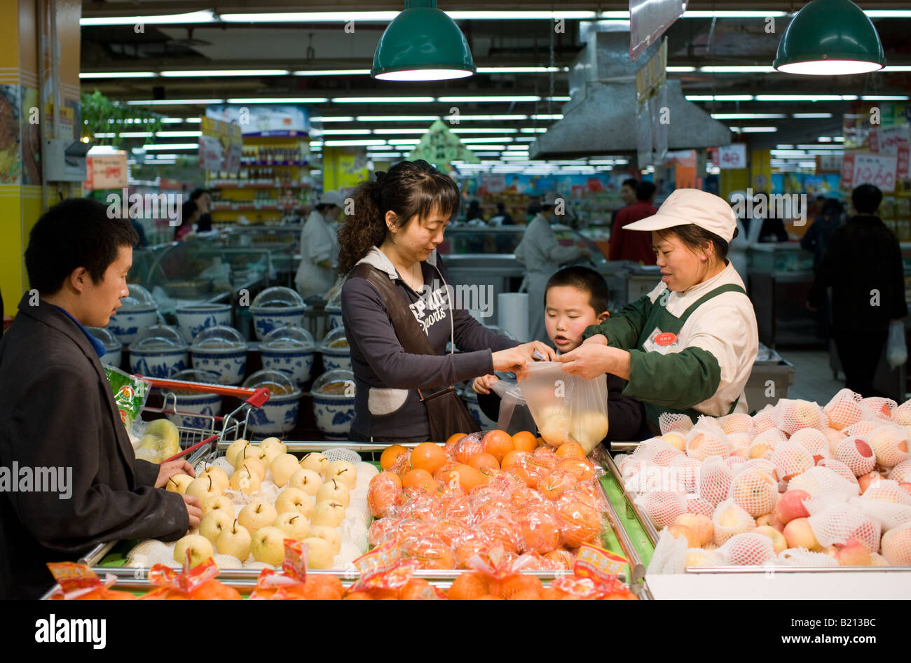 La madre e il bambino di acquistare verdure nel supermercato Chongqing nella provincia del Sichuan in Cina Foto Stock