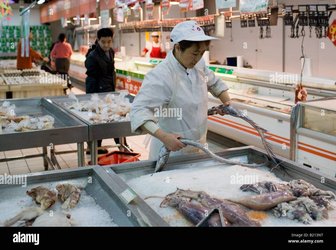 Shop assistant al pesce fresco contatore nel supermercato di Chongqing Cina Foto Stock