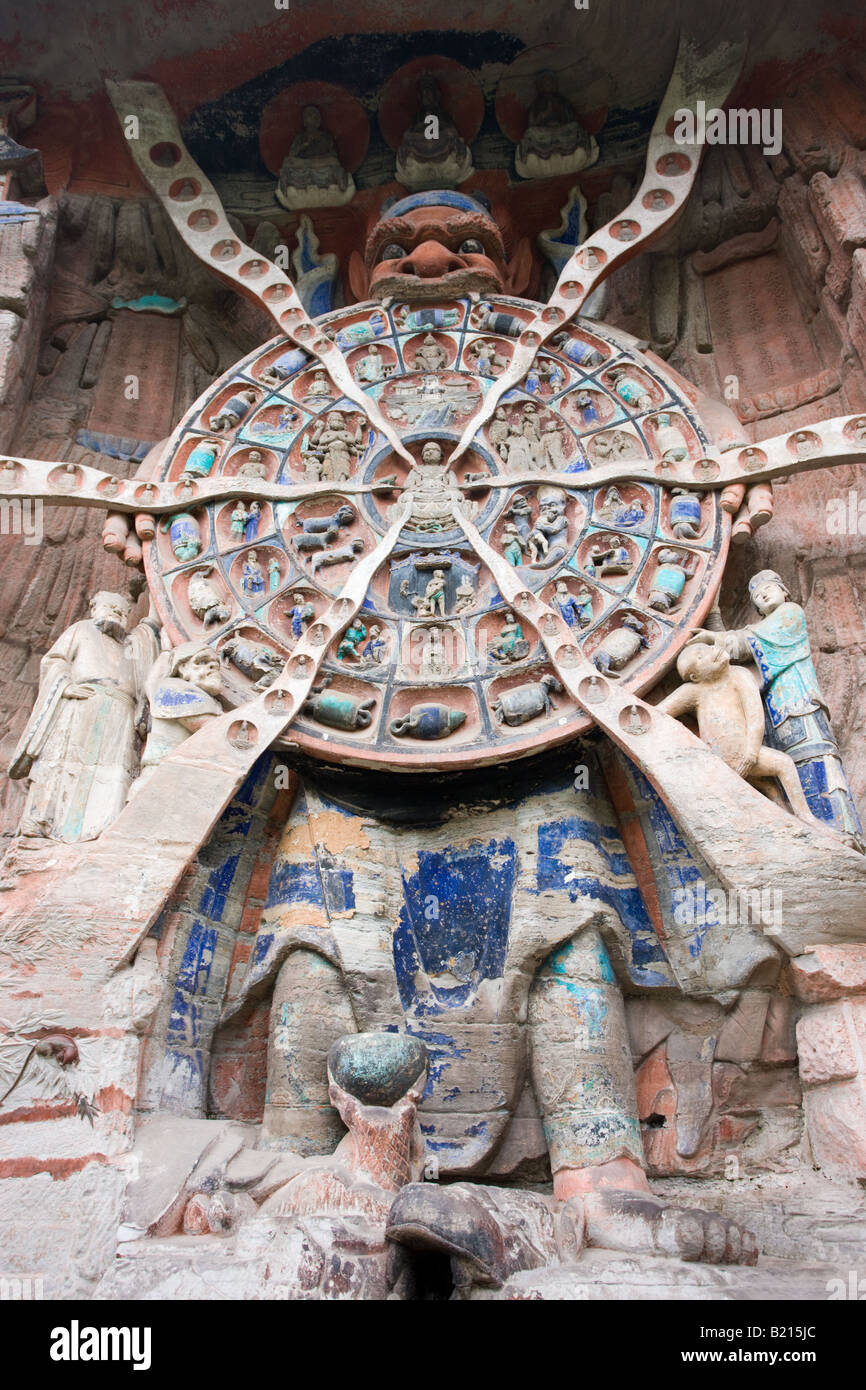 Anicca dio del destino mantiene la ruota della vita del karma buddista Dazu incisioni rupestri Monte Baoding in Cina Foto Stock