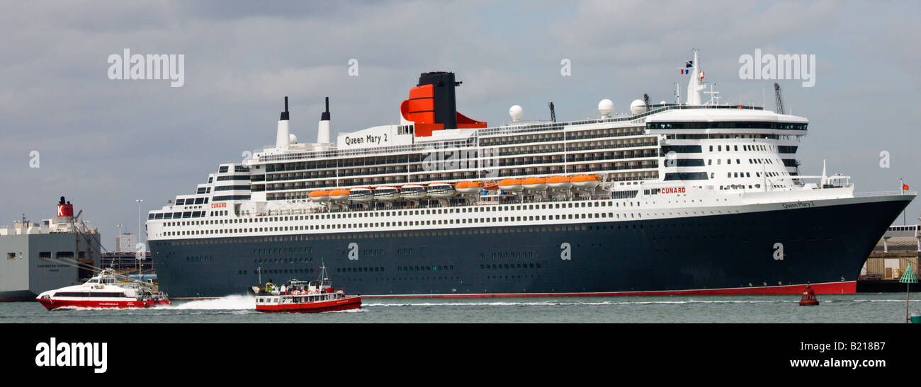 Traghetti passando accanto ad un liner Cunard Queen Mary 2 in acqua di Southampton Hampshire Inghilterra Foto Stock