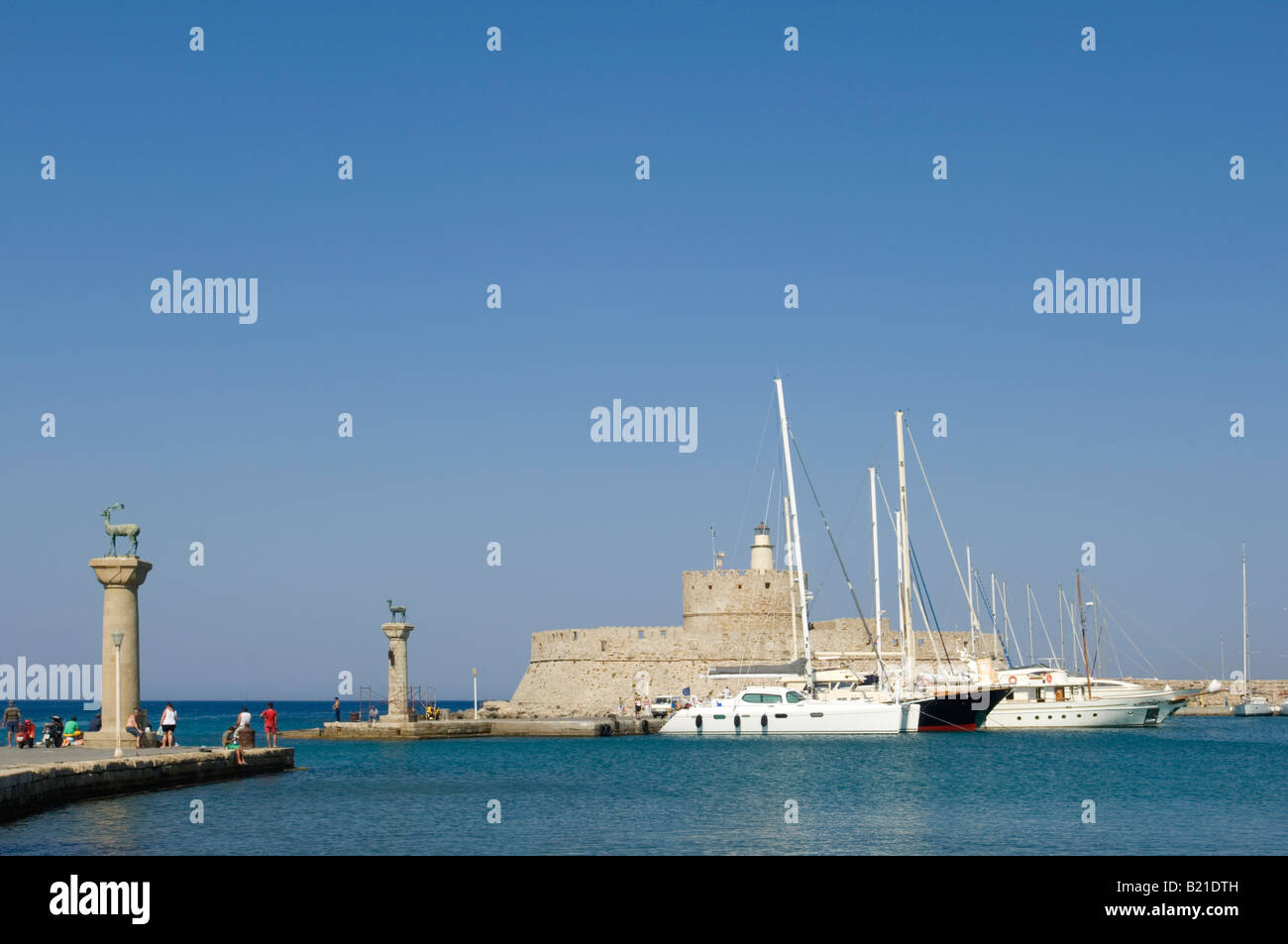 Il dollaro e il DOE deer statue che guardia su alte colonne all'entrata di Mandraki Harbour per l' isola di Rodi. Foto Stock