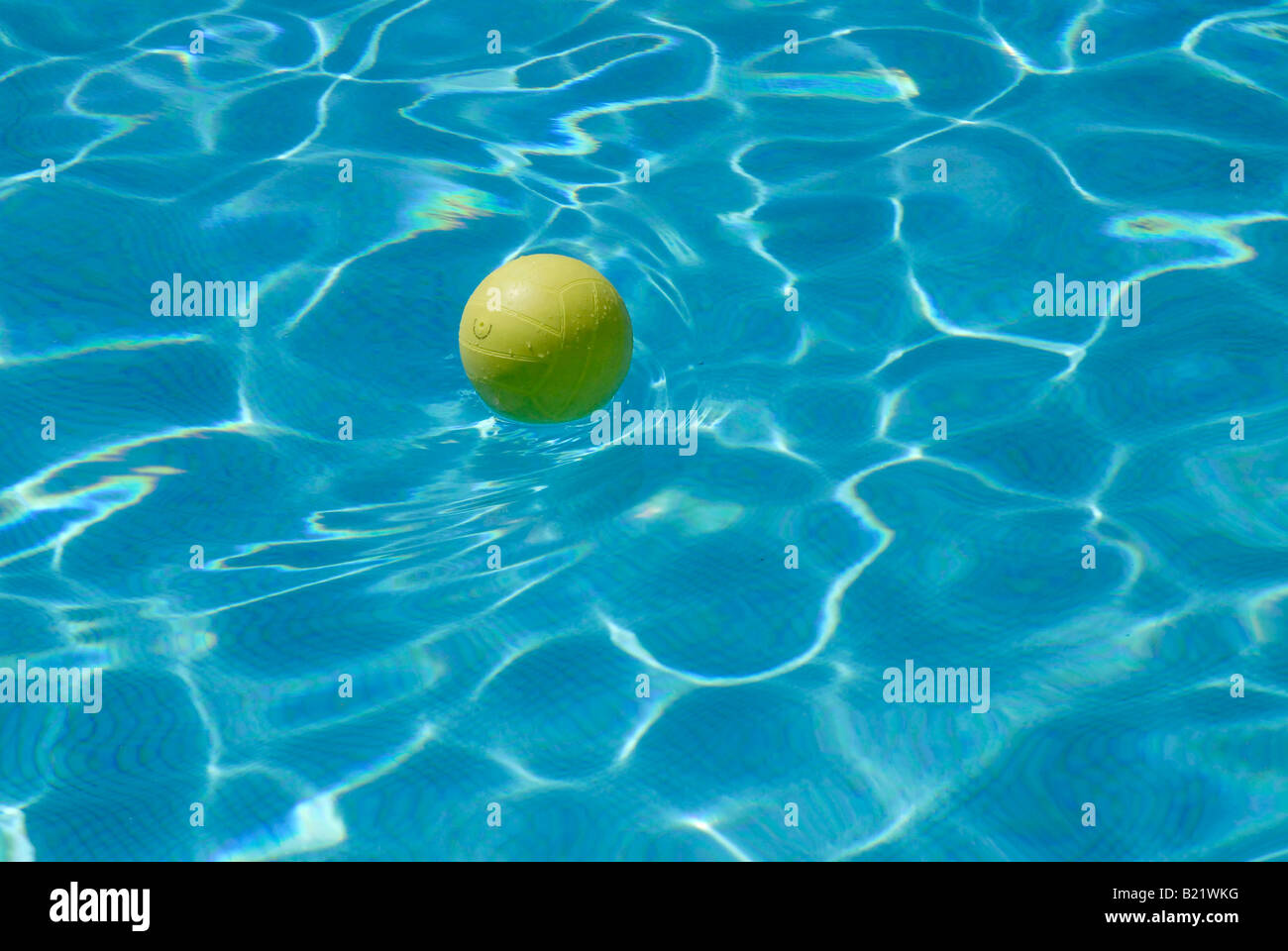 Giallo pallanuoto sfera sulla superficie di un azzurro piscina Foto Stock