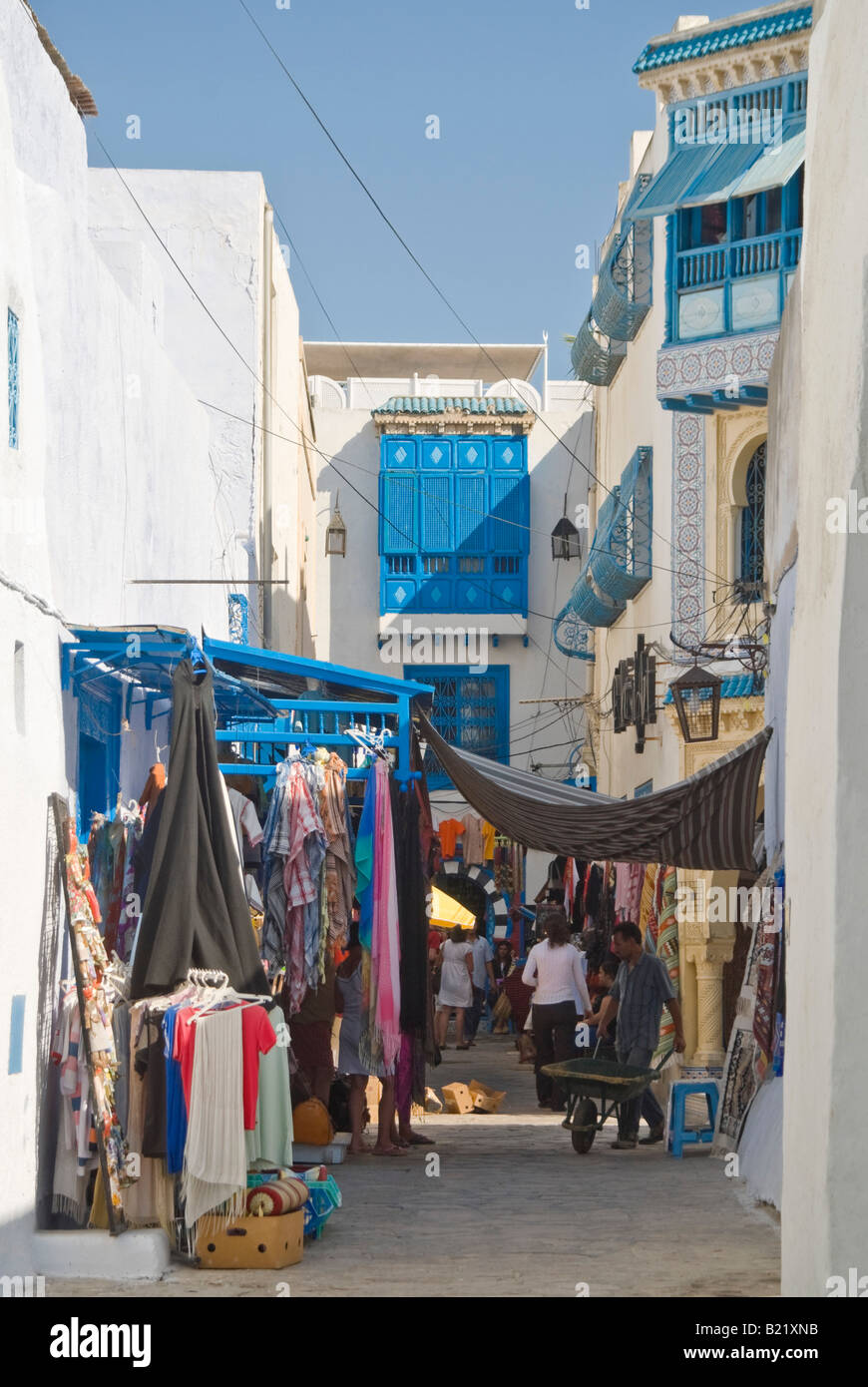 Vista verticale di un tipico streetscene con edifici bianchi e vicoli stretti all'interno della vecchia Medina a Hammamet in una giornata di sole Foto Stock