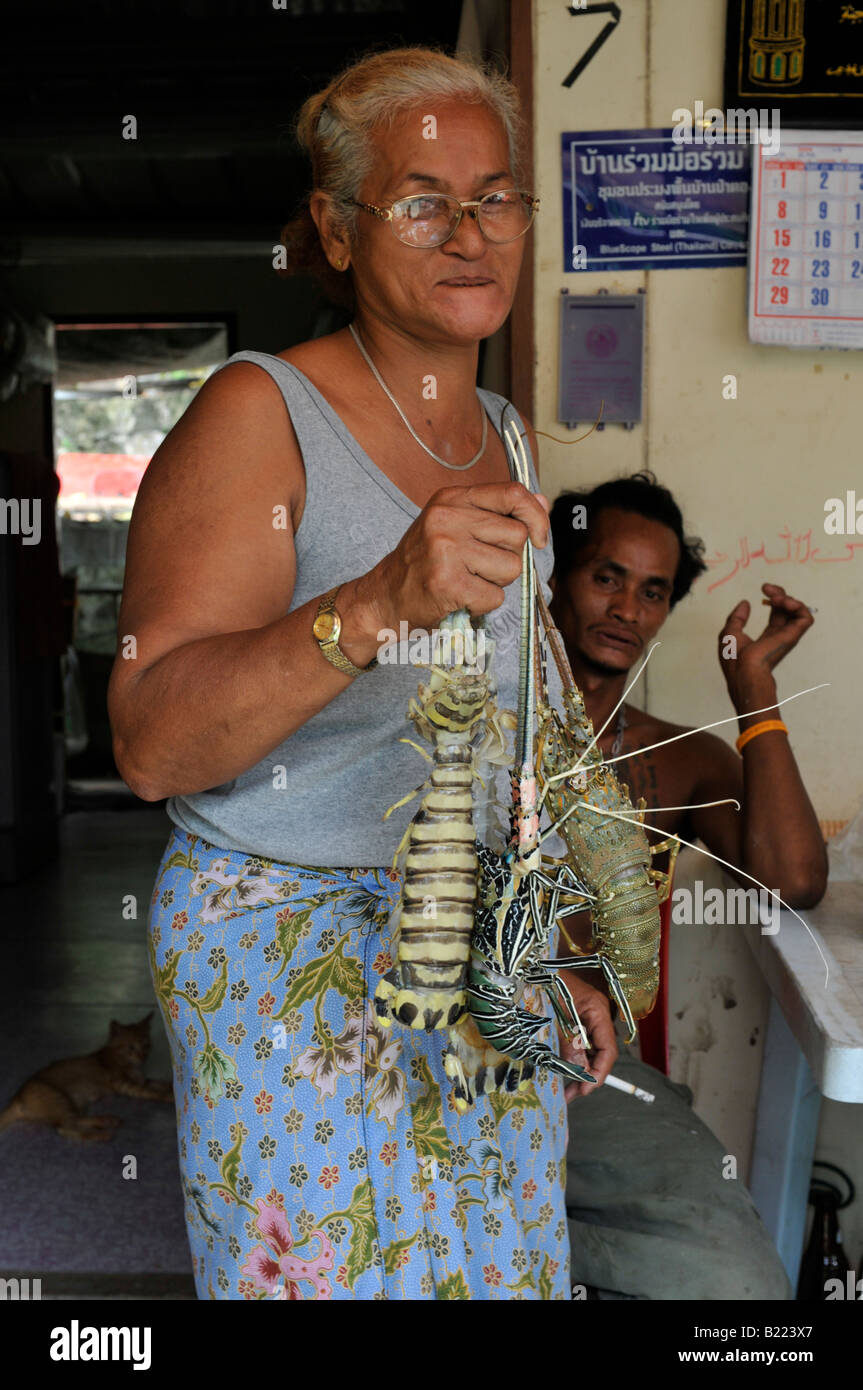 Signora superstite di tsunami , maria, mostrando le aragoste appena catturati , patong beach , della Thailandia Foto Stock