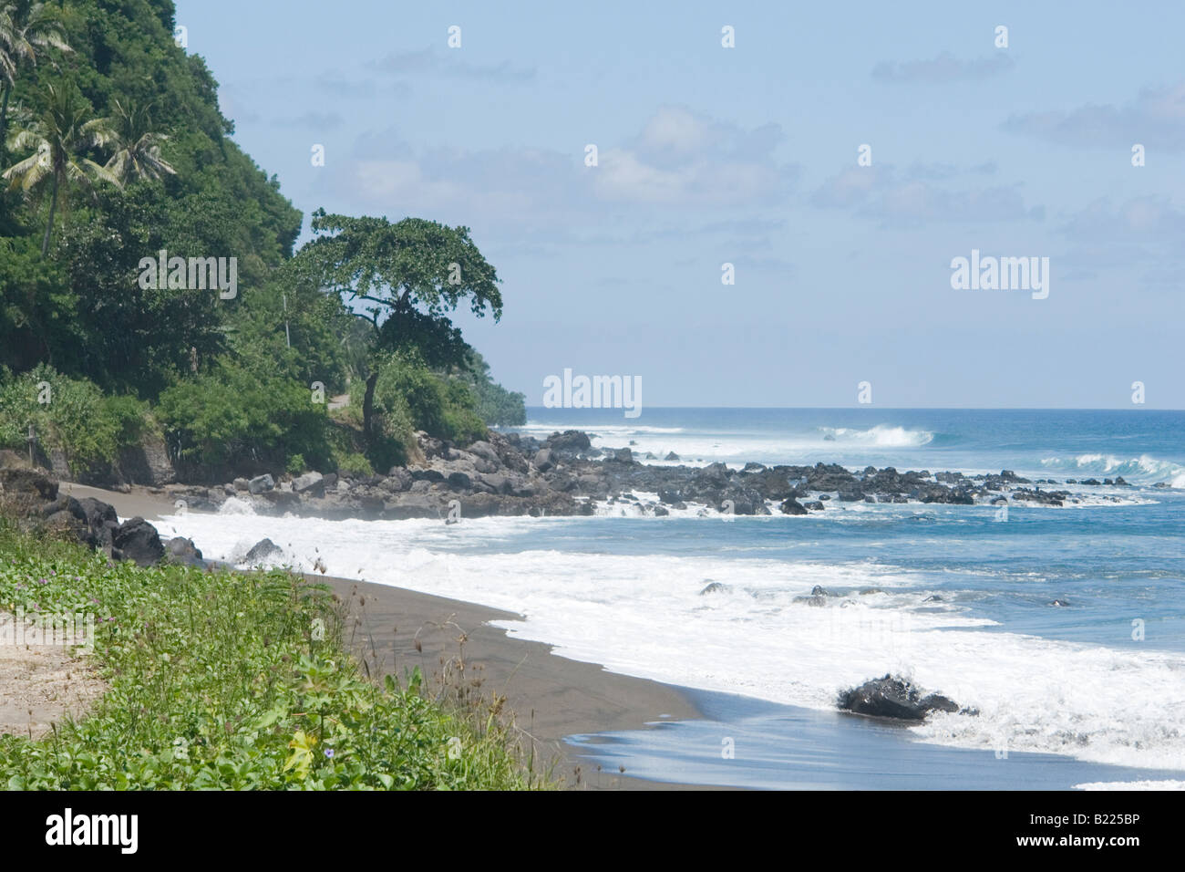 La rocciosa spiaggia di sabbia nera vicino a Sikka (Flores - Indonesia). La plage rocheuse de sable noir, près de Sikka (Flores-Indonésie) Foto Stock