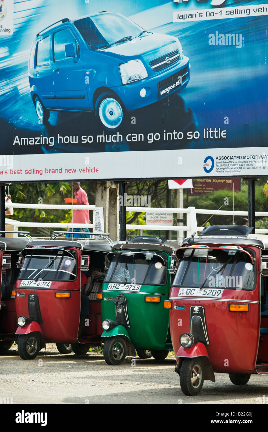 Auto rickshaws parcheggiato sotto un auto annuncio nella Galle, Sri Lanka. Foto Stock