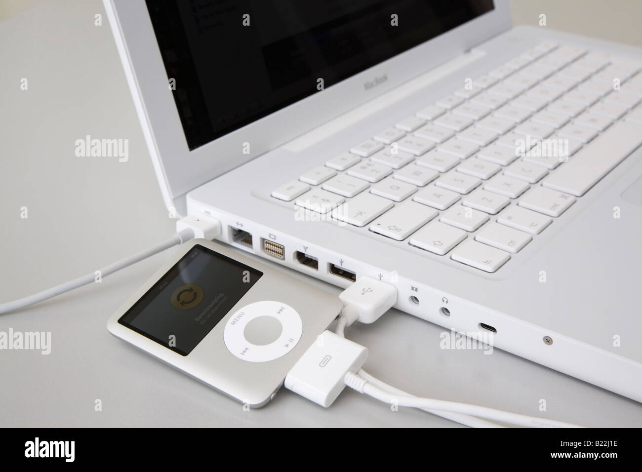 Apple ipod nano lettore MP3 sincronizzazione collegato al MacBook bianco computer portatile porta USB Foto Stock
