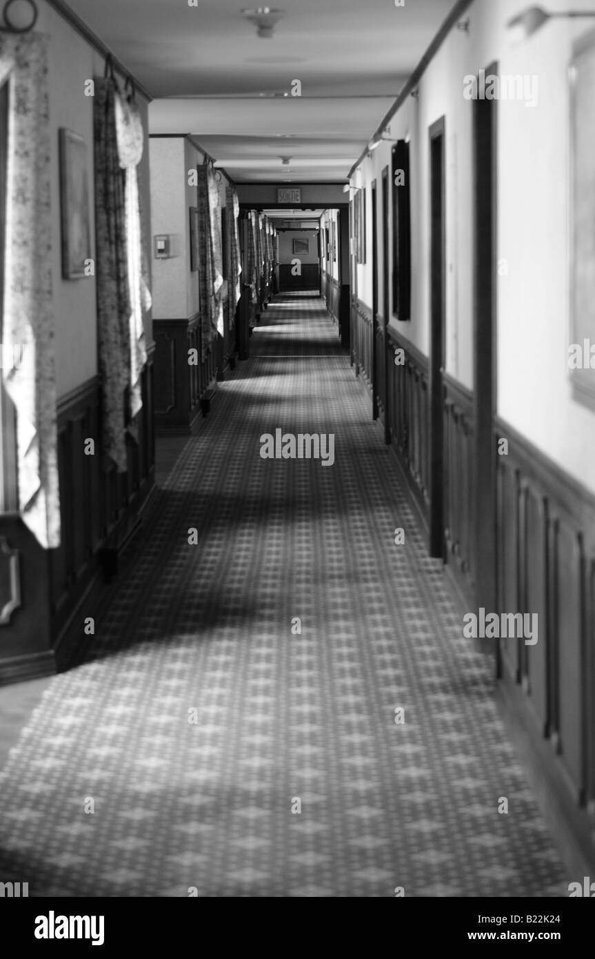 Fotografia in bianco e nero di un lungo e apparentemente senza fine corridoio. Foto Stock