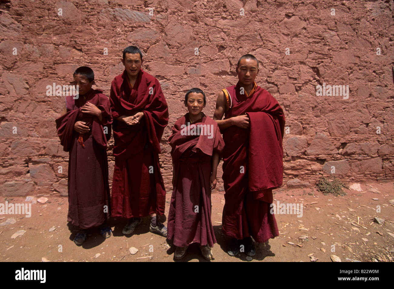 Monaci Tibetani stand al di fuori del loro monastero di Ganden in Tibet Foto Stock