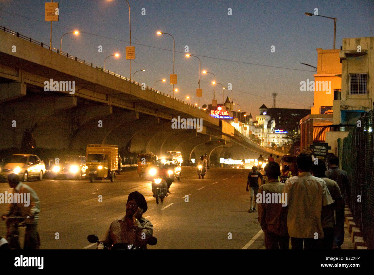 Di sera su una strada a Hyderabad, in India. La strada è illuminata da lampioni e un cavalcavia può essere visto. Foto Stock