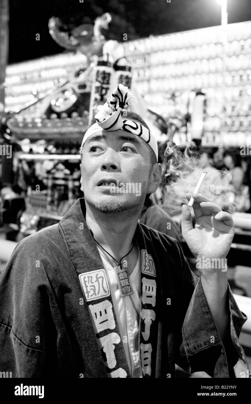 Uomo giapponesi in costume tradizionale di fumare una sigaretta al Festival Mitama (Matsuri) a Tokyo in Giappone Foto Stock