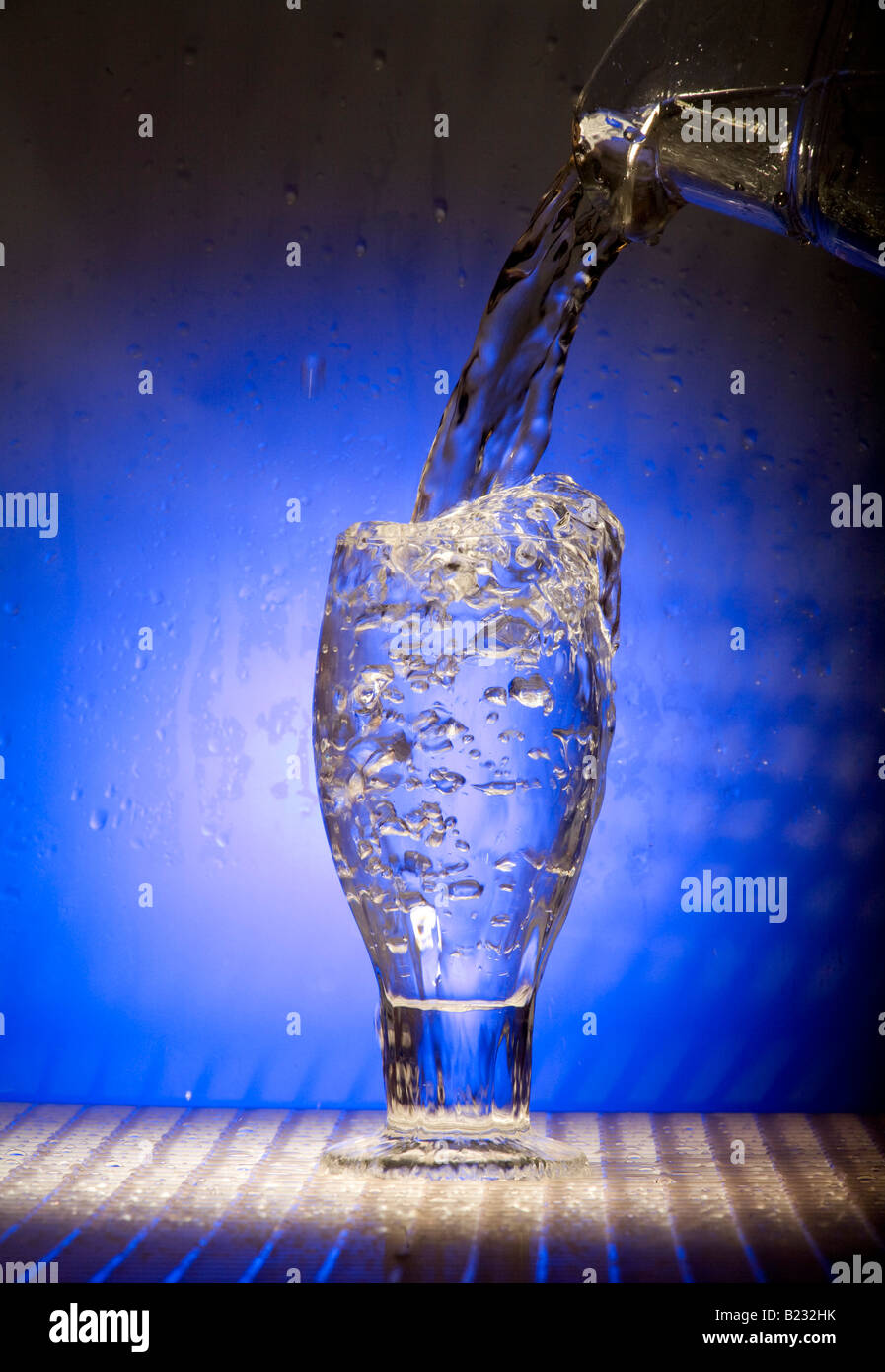L'acqua si riversa nel bicchiere Foto Stock