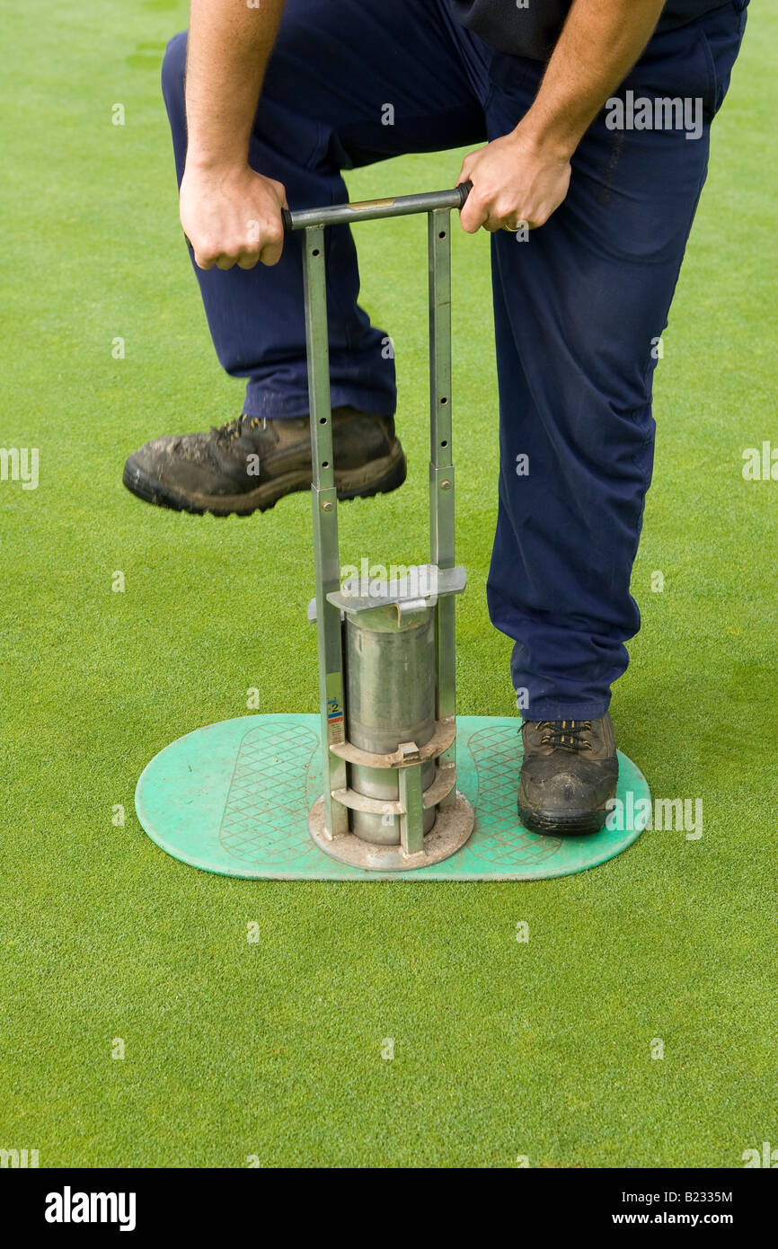 Greenkeeper foro di taglio in putting green Foto Stock