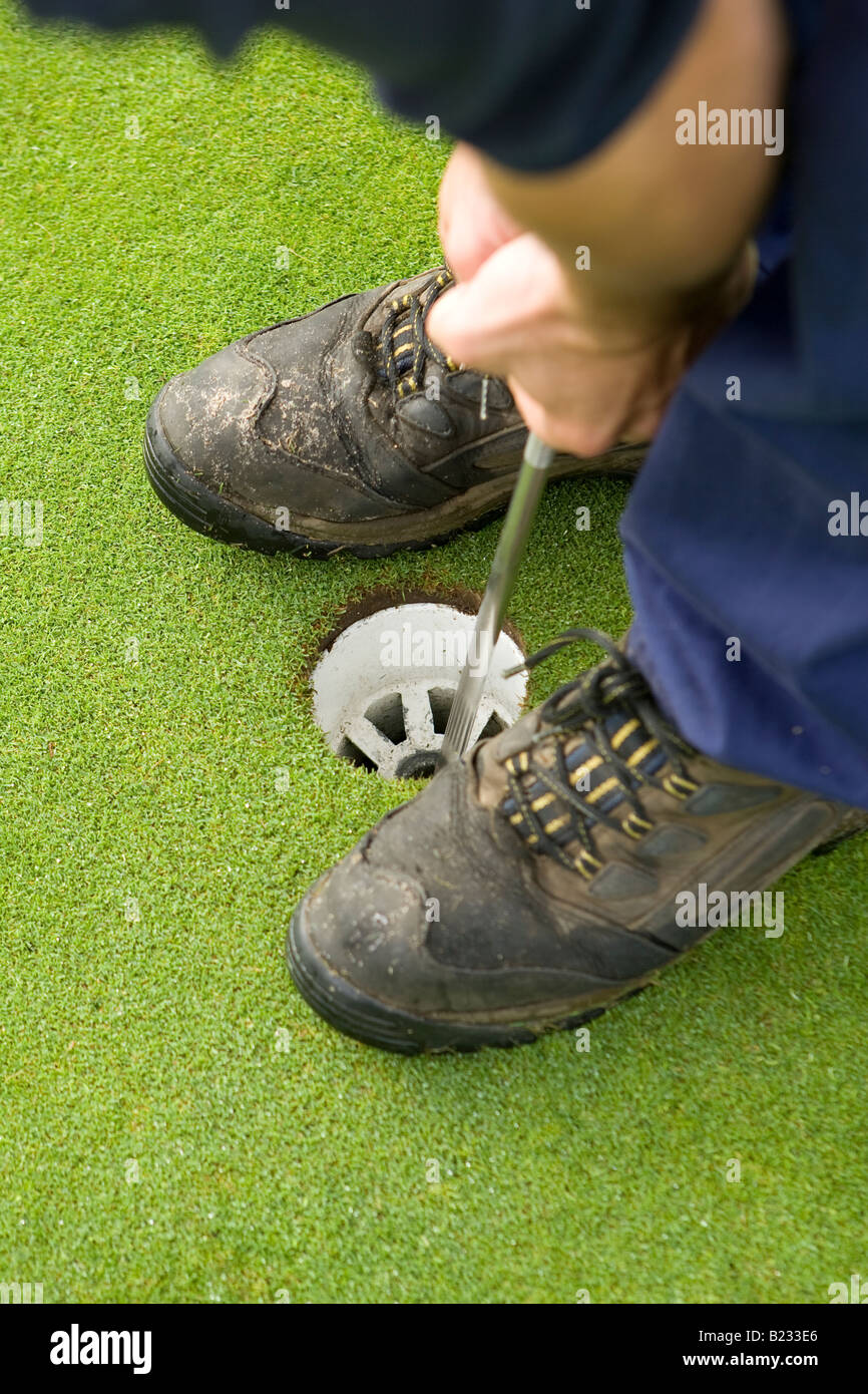Greenkeeper foro di taglio in putting green Foto Stock