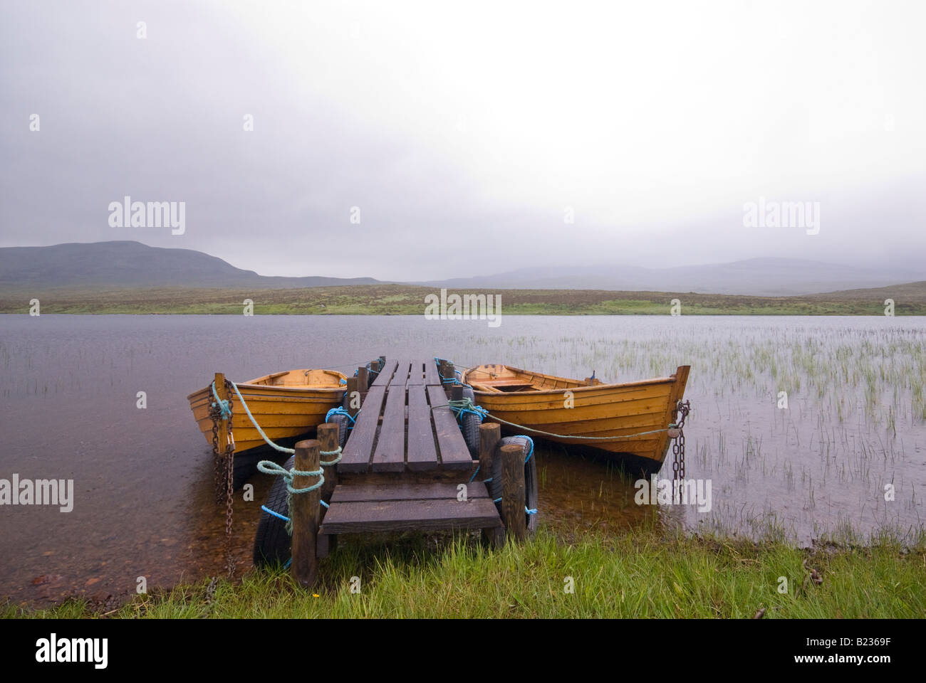 Barche a Scottish Loch in Rain Foto Stock