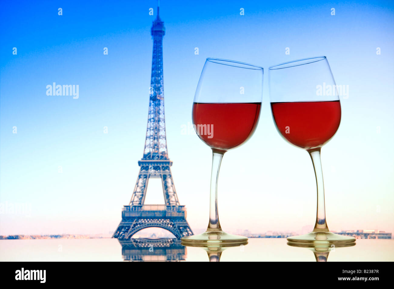 Parigi Torre Eiffel due bicchieri di vino sporgersi verso ogni altro sul tavolo di vetro con la Torre Eiffel dietro. Parigi cafe bar Francia Foto Stock